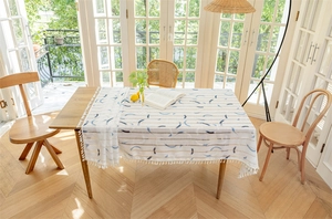 Nahaufnahme von geometrischen Wellenmustern und weißen Quasten auf der Tischdecke