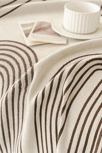Close-up of beige Chenille throw blanket featuring dark brown geometric arch patterns