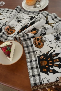 Close-up of Halloween table runner featuring pumpkins and ghosts with elegant tassel fringe