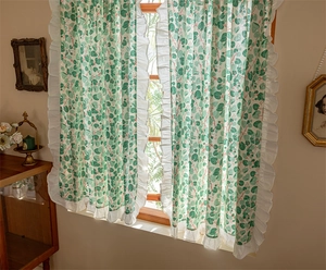 Detail of cotton cafe curtain with green vine prints and elegant white ruffle borders