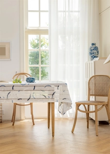 Detail einer geometrisch gestreiften Jacquard-Tischdecke mit Fransen auf einem Holztisch
