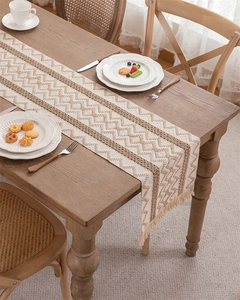 Close-up of woven chevron cotton linen table runner with fringes on a wooden table