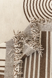 Detailed macro view of Nordic chenille sofa throw with geometric patterns and fringe