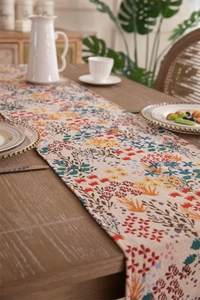 Detail of woven table runner featuring vibrant wildflower patterns and tassel edges
