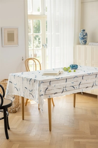 Detail der weißen Tischdecke mit dunkelblauen Halbmondmustern und beigen Streifen