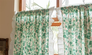 Detailed view of green leaf floral cotton curtain with elegant white ruffled edge accents