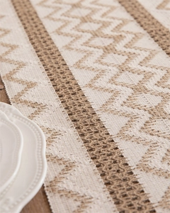 Macro detail of hand-woven cotton linen table runner with chevron pattern and tassels