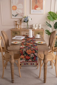Close-up of vintage floral jacquard table runner with decorative tassel fringe detail