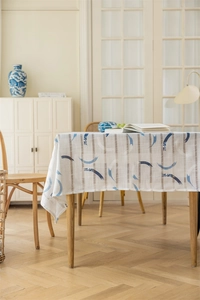 Detailaufnahme der geometrischen Jacquard-Tischdecke mit blauen Bogenmustern und Fransen