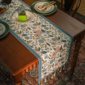Runner da tavola jacquard floreale con nappine su tavolo da pranzo in legno