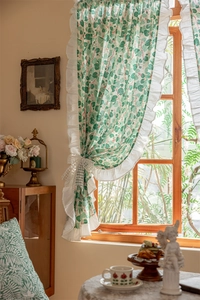 Detailed view of pastoral cotton curtain with green leaf pattern and white ruffle edges