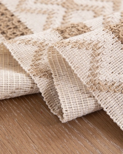 Macro detail of Bohemian woven table runner showing geometric texture and tassels