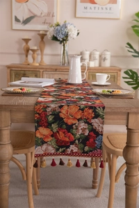 Close-up of vintage floral jacquard table runner with colorful woven tassel fringe detail