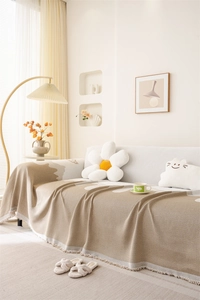 Detail of Nordic chenille sofa cover with floral jacquard patterns and elegant fringe edge