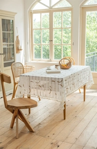 Detailansicht der Tischdecke mit geometrischem Halbmondmuster und weißen Fransen