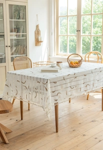 Detailansicht der cremefarbenen Tischdecke mit Mondsicheldruck und feinen Fransenrändern