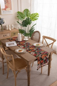 Close-up of vintage floral jacquard table runner with decorative tassel fringe details