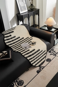 Close-up of geometric black and white jacquard sofa mat with irregular wavy edges
