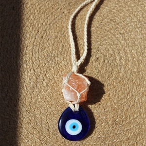 Handmade Evil Eye pendant with orange crystal stone on a beige woven cord necklace