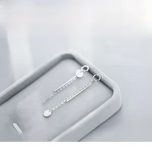 Macro shot of S925 sterling silver asymmetrical chain earrings on grey velvet