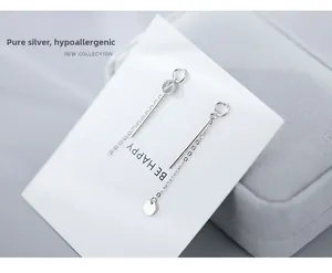 Detail of S925 sterling silver long chain earrings with minimalist disk pendant design