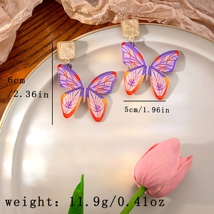 Detail of oil painting butterfly drop earrings with marble square stud on ceramic tray