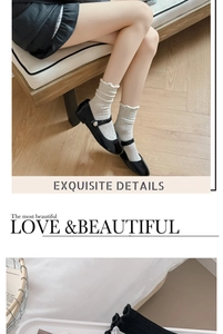 Close-up of white ruffle edge pile socks worn with black Mary Jane shoes