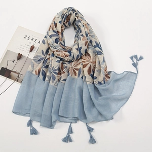 Artistic linen cotton scarf with blue leaf print and fringed edges on white background