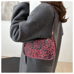 Dettaglio della borsa baguette leopardata in magenta e nero con zip in metallo dorato