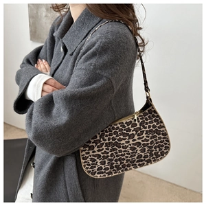 Borsa baguette leopardata indossata da una modella in un cappotto invernale grigio