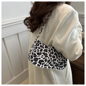 Dettaglio della borsa baguette leopardata bianca e nera indossata da una modella