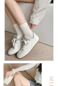 Close-up of white mesh mid-calf socks with floral pattern worn with white sneakers