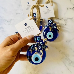 Blue glass Turkish Evil Eye pendant with hemp rope and symbolic card on marble