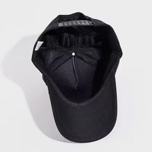 Detail view of black baseball cap interior construction with adjustable plastic strap