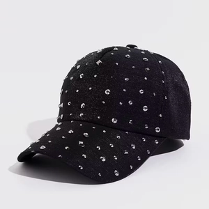 Close-up of sparkling rhinestones and silver studs on a black stylish baseball cap