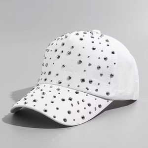 Close-up of white baseball cap with dense grey rhinestones and stud textures
