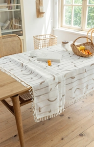 Nahaufnahme der geometrisch bedruckten Tischdecke mit eleganten Fransen auf Holztisch