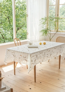 Detailaufnahme der cremefarbenen Tischdecke mit hohlem geometrischem Muster und Fransen