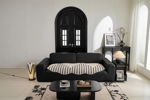 Close-up of beige wavy-edged geometric jacquard sofa cover on black leather furniture