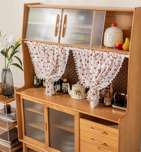 Detail of red strawberry print cotton curtain on a rustic wooden cabinet shelf