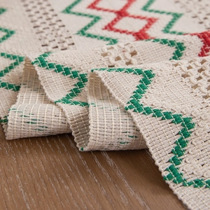 Handwoven table runner with colorful geometric embroidery and tassels on cotton linen fabric