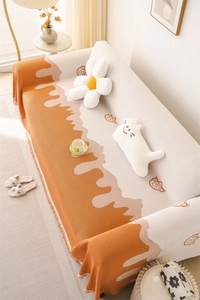 Macro view of Nordic chenille sofa throw with orange fluid jacquard and bear pattern