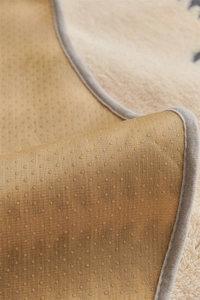 Detailed close-up of anti-slip dotted backing and grey reinforced edge on plush sofa cover