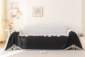 Detailed view of Nordic black chenille sofa cover with jacquard geometric pattern and tassels