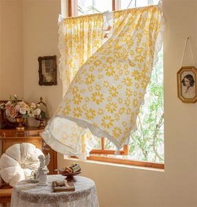 Detail of yellow daisy print cotton curtain with white ruffled edges in retro style