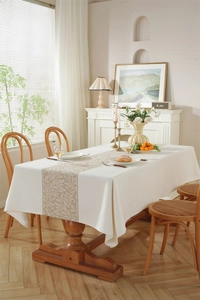 Détail du tissage jacquard géométrique vintage sur une nappe blanche et marron