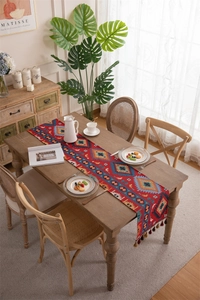 Close-up of bohemian red table runner with geometric patterns and fringe tassels