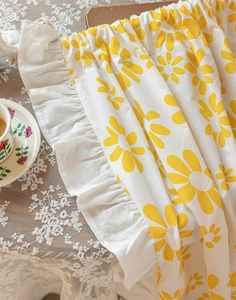 Close-up of cotton door curtain with yellow daisy print and elegant ruffle edge
