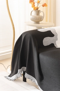 Close-up of Nordic chenille throw blanket with jacquard geometric patterns and tassels