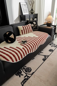 Close-up of thick jacquard sofa cushion with red wavy patterns and plush texture